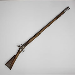 Colour photograph of a wooden rifle with iron pieces.