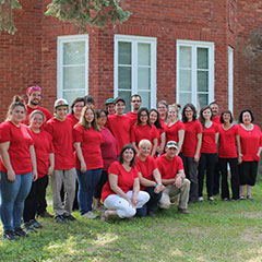 Colour photograph of all the members of the Fort d'Odanak project. They are all wearing red shirts.
