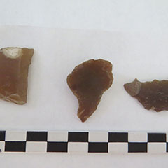 Colour photograph of three gunflints. They all have different shapes.