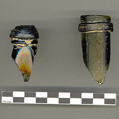 Colour photograph of two broken glass bottlenecks.