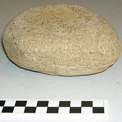 Colour photograph of a round and slightly flattened stone.