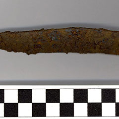 Colour photograph of a rusted iron knife blade.