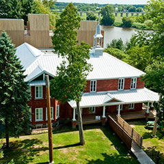 Overhead colour photograph of the Musée made of red bricks. In the distance, you can also see the river.