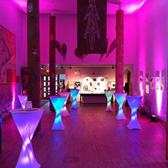 Colour photograph of the hall at the Musée des Abénakis with a pinkish light atmosphere.